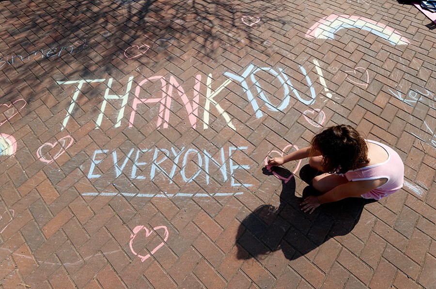 A girl draws a thank you message on the pavement in Broadway as the spread of the coronavirus disease (COVID-19) continues, Broadway, Britain